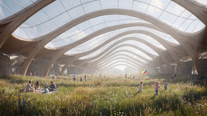 Families on a flowering meadow under a long timber and glass roof.