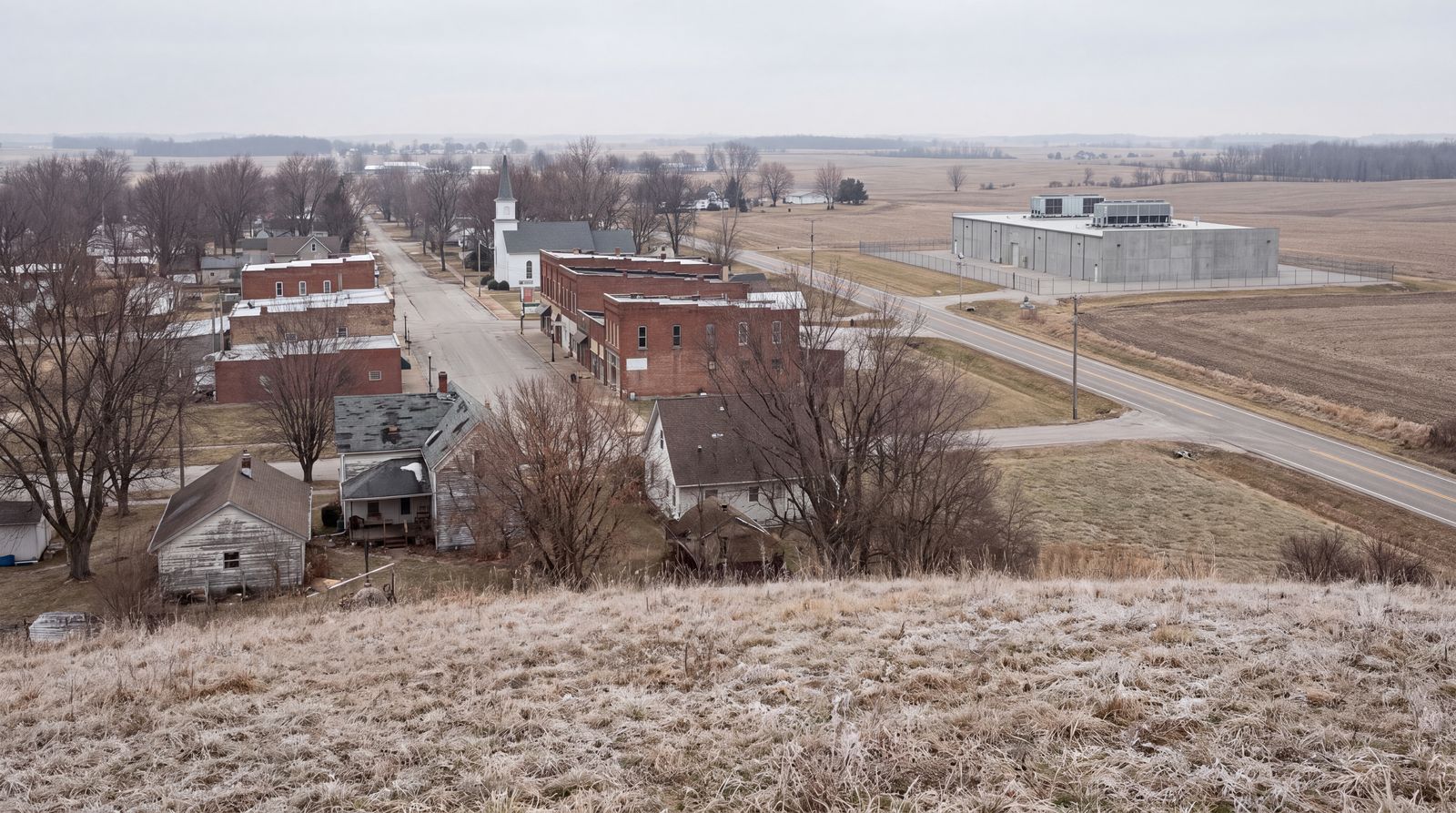 A small town in late winter with a plain gray data center at its edge.